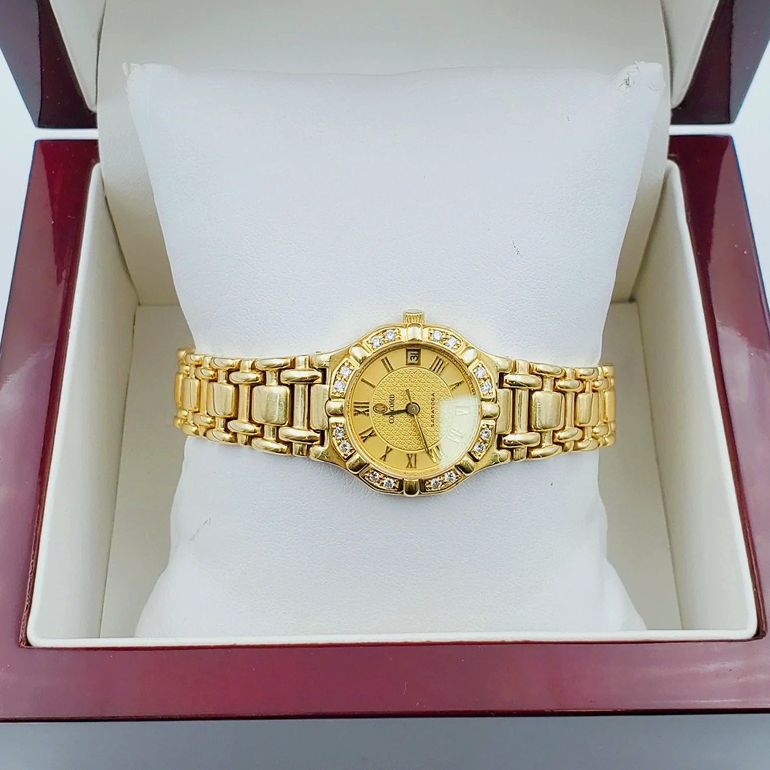 Ladies Concord Sarento 24mm Solid 18K Yellow Gold Band Watch with Roman Numeral Gold Dial and Diamond Bezel. (Pre-Owned)