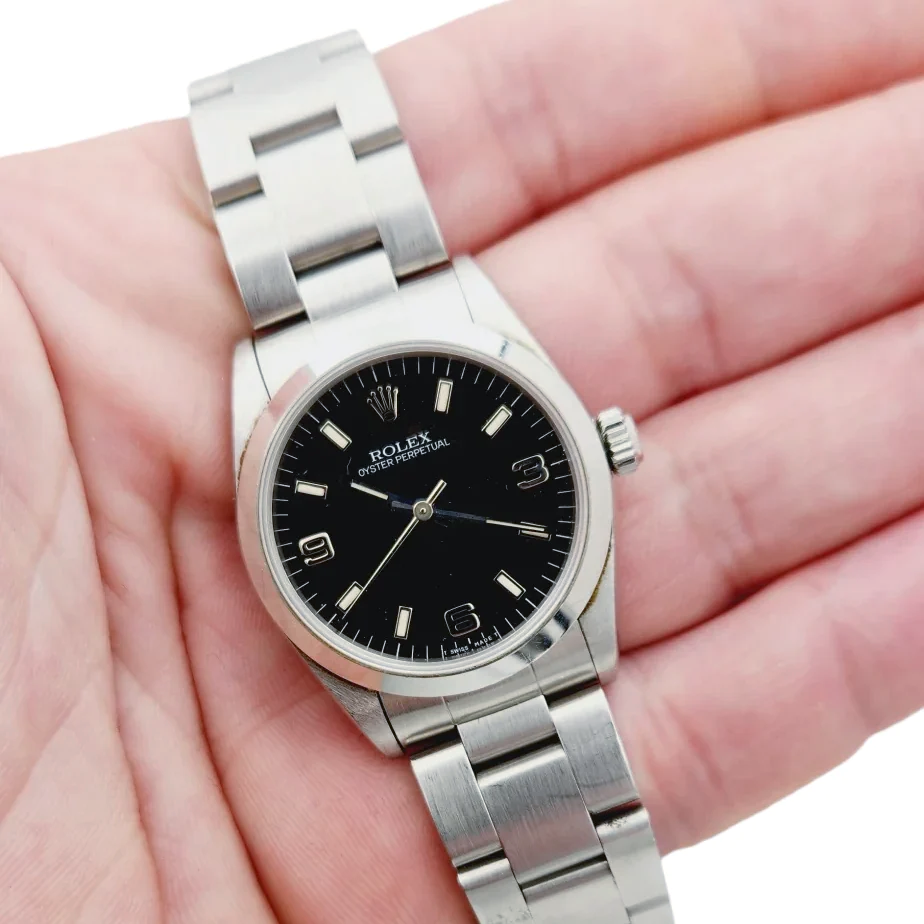 Ladies Rolex 31mm Midsize Oyster Perpetual Stainless Steel Watch with Black Dial and Smooth Bezel. (Pre-Owned 67480)