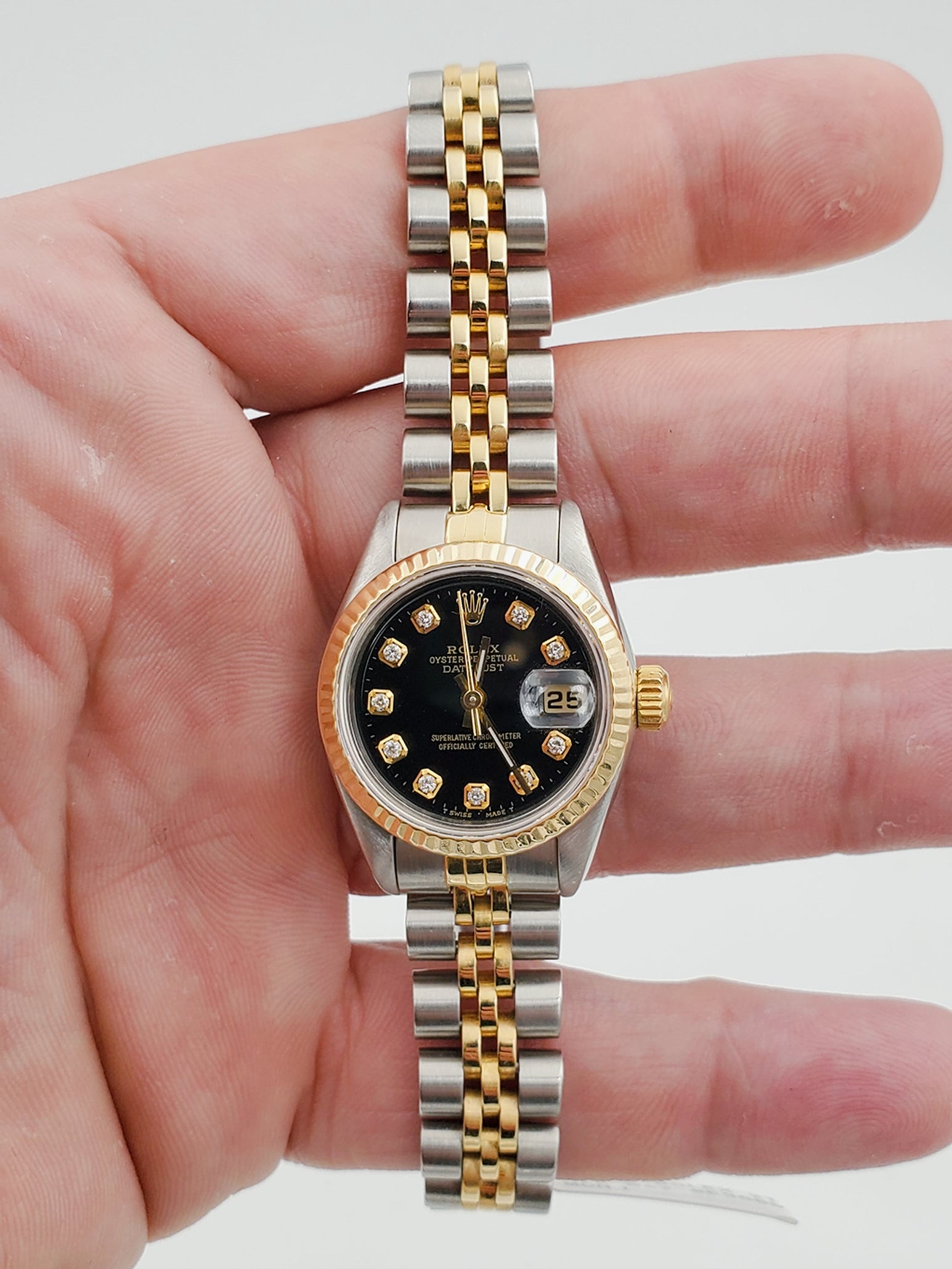 Ladies Rolex 26mm DateJust Two Tone 18K Gold / Stainless Steel Watch with Black Diamond Dial and Fluted Bezel. (Pre-Owned)