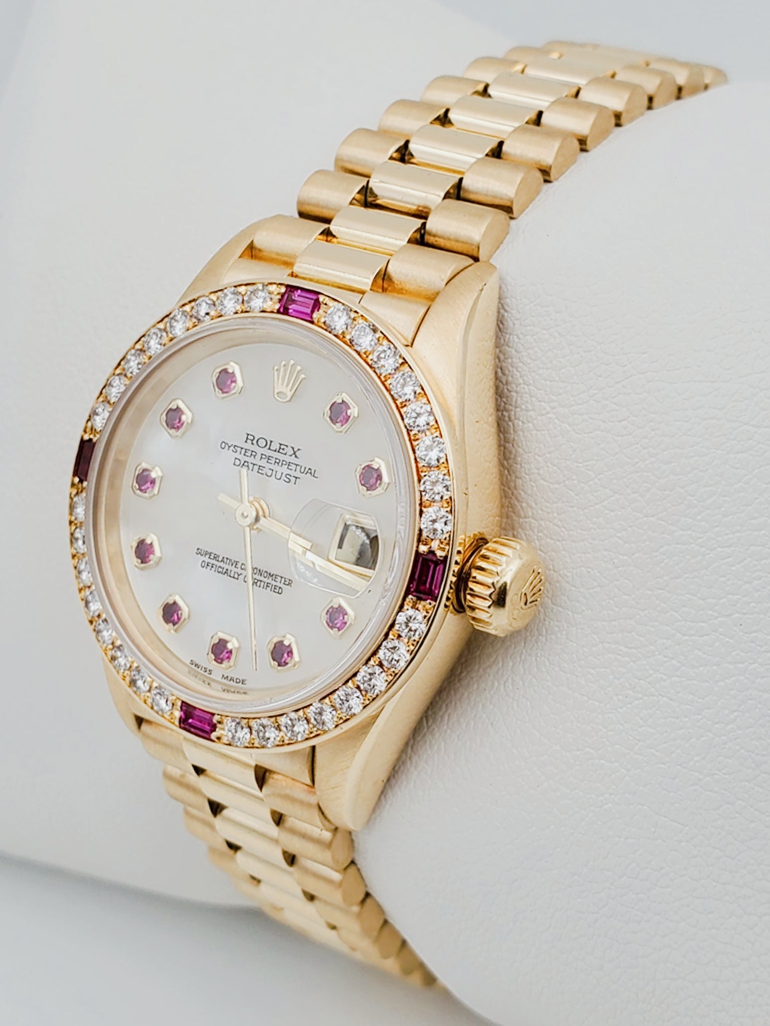 Ladies Rolex Presidential 26mm Solid 18K Yellow Gold Watch with Mother of Pearl Ruby Dial and Diamond Bezel. (Pre-Owned 7906B)