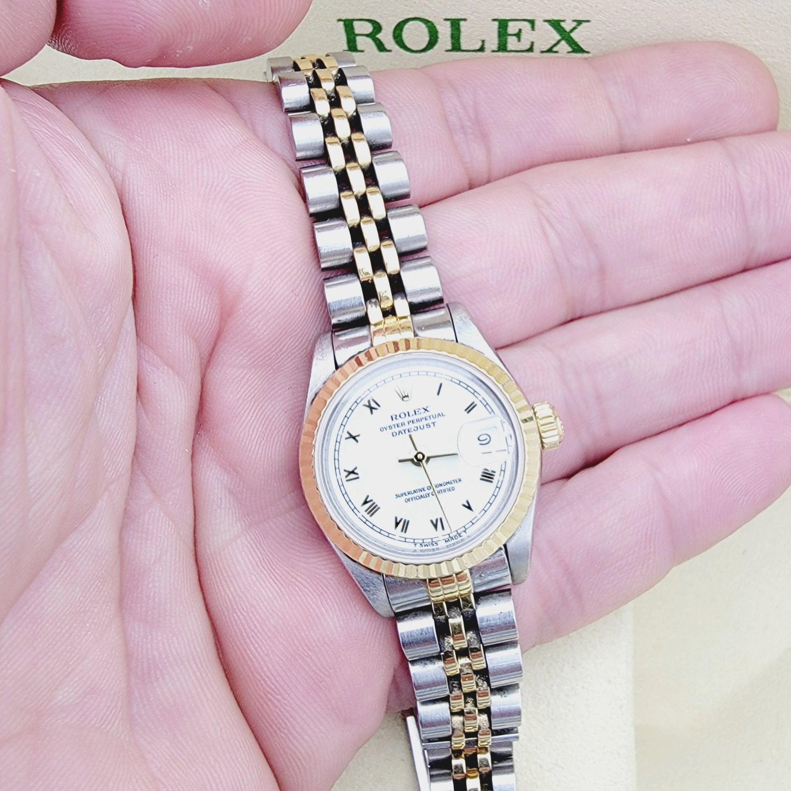 Ladies Rolex 26mm DateJust 18K Yellow Gold / Stainless Steel Two Tone Watch with Roman Numerals White Dial and Fluted Bezel. (Pre-Owned 69173)